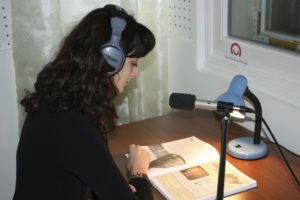 Vivette Rifkin reading a textbook into a microphone