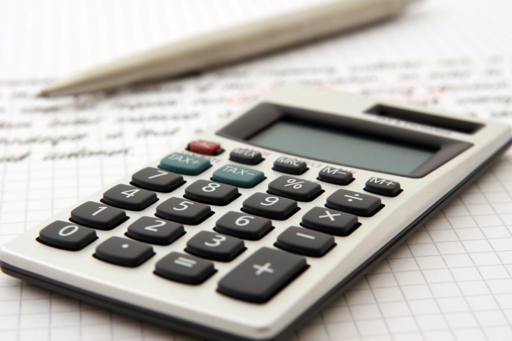 A calculator on top of graph paper with a pen to the side