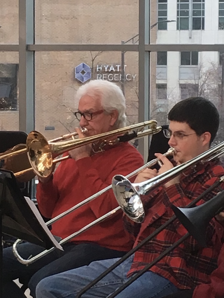 A new photo of Doug and Grant playing trombones together at a concert
