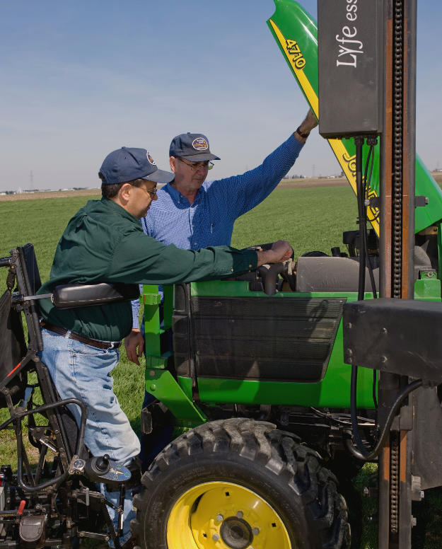 Farmer and partner working on a tractor. Farmer is using a standing wheelchair