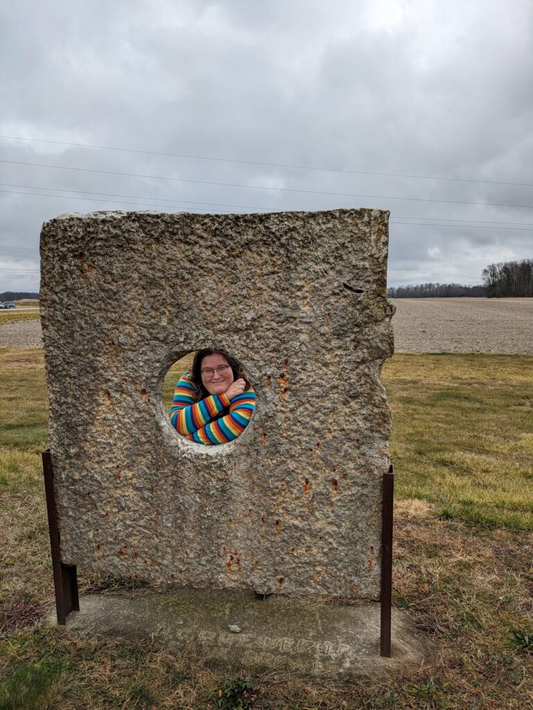 Megan looking through a peephole at Stonehenge 