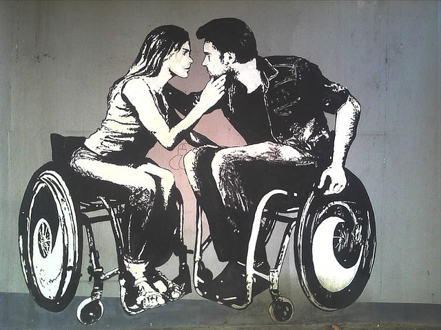 Graffiti art of two disabled wheelchair users kissing