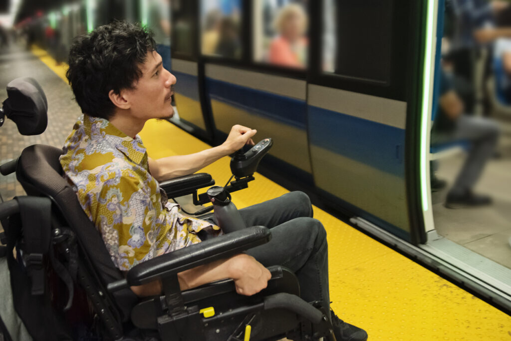 Person using a wheelchair about to board a subway train