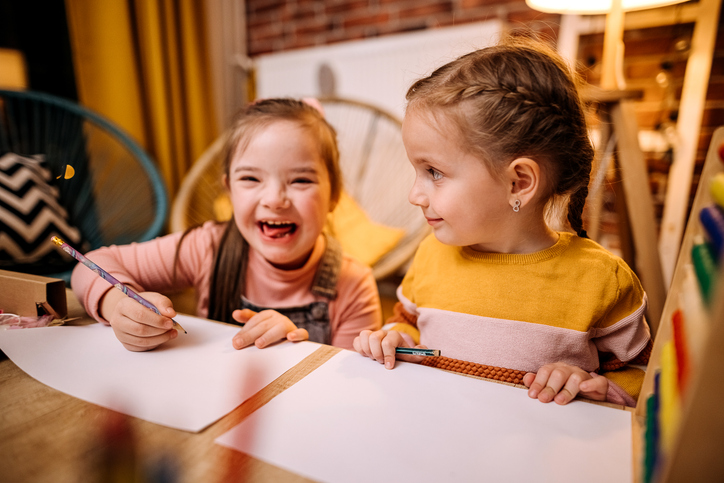 Shot of two sisters completing their homework togethe